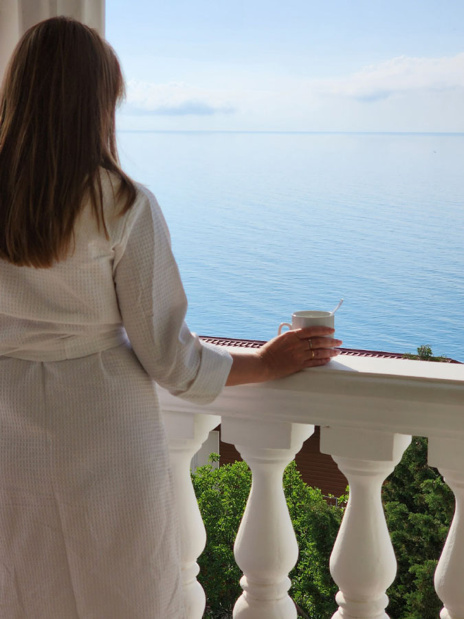 Гостья пьет кофе на балконе 